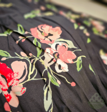 schwarzer Stoff mit rosa und roten Blumenmotiven