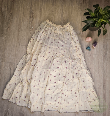 Cremiger Boho-Rock mit kleinen lavendelfarbenen Sternen und elastischem Bund, auf hellem Boden mit Kristallen und Pflanze drapiert
