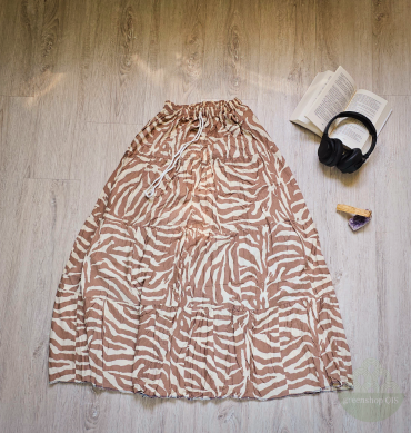 Boho Maxirock mit beige-cremefarbenem Zebra-Muster, ausgebreitet auf hellem Boden neben Buch, Kopfhörern, Palo Santo und Amethyst.